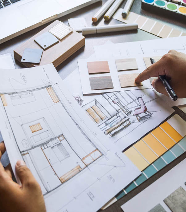 Architectural plans and material samples being reviewed.